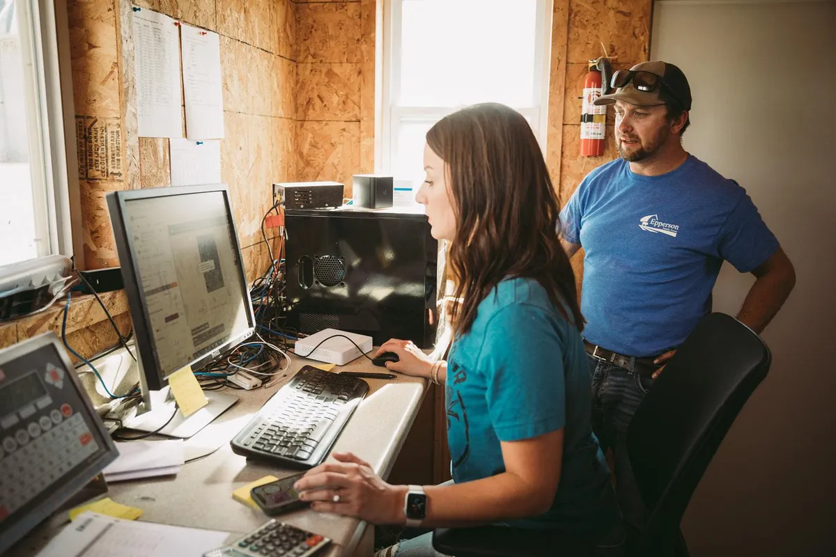 A farm team reviewing their operation's numbers on the office computer